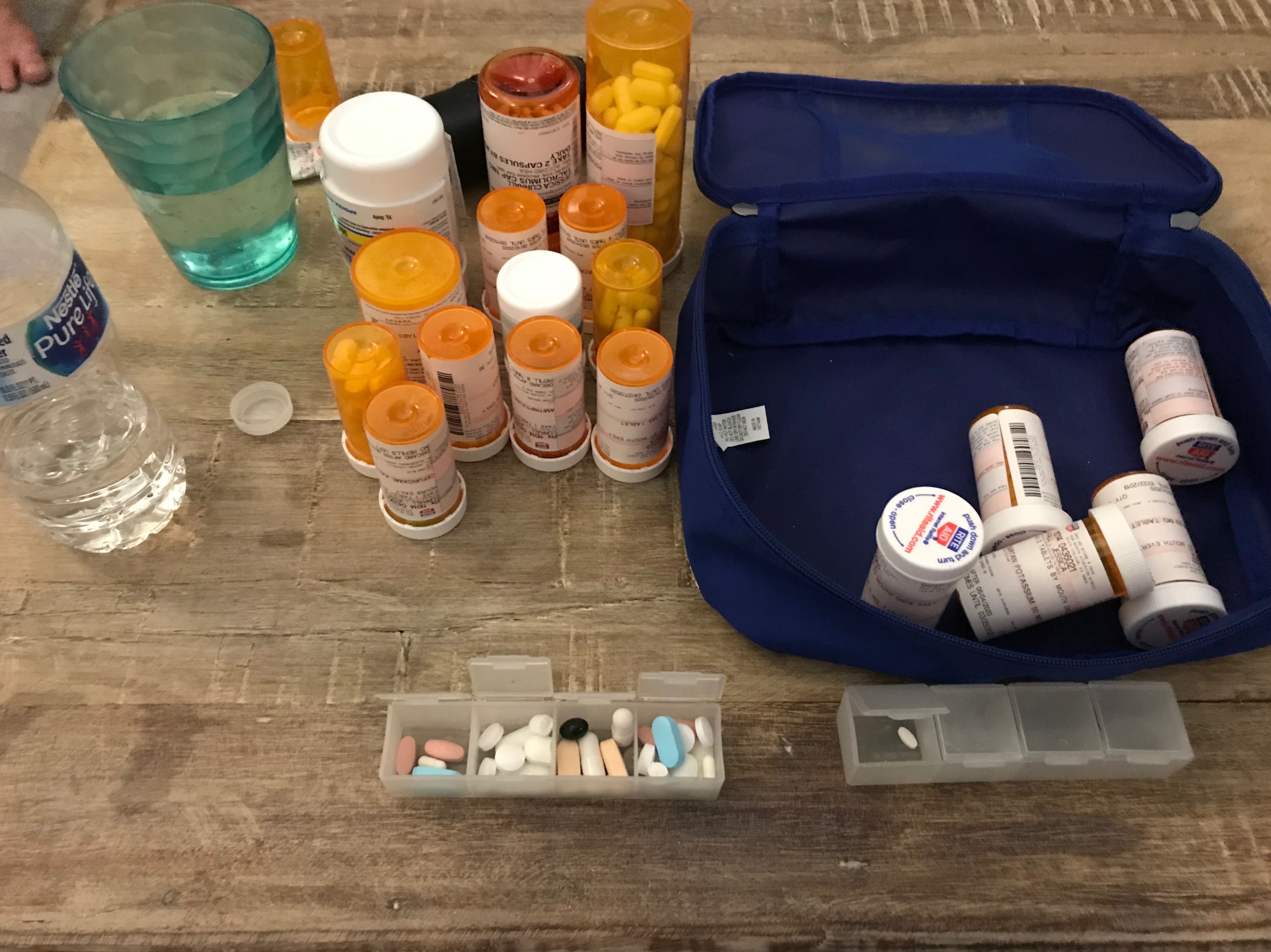 Table view of prescription medications in bottles and in a travel bag